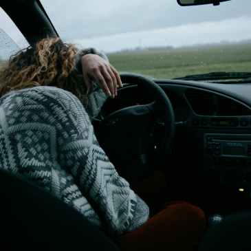 unrecognizable woman sitting in car