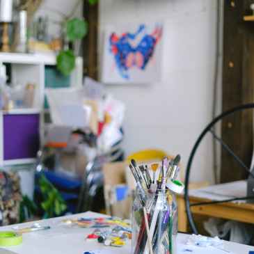 paint brushes in jar on table in professional craft shop