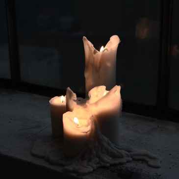 burning candles with melted wax at night