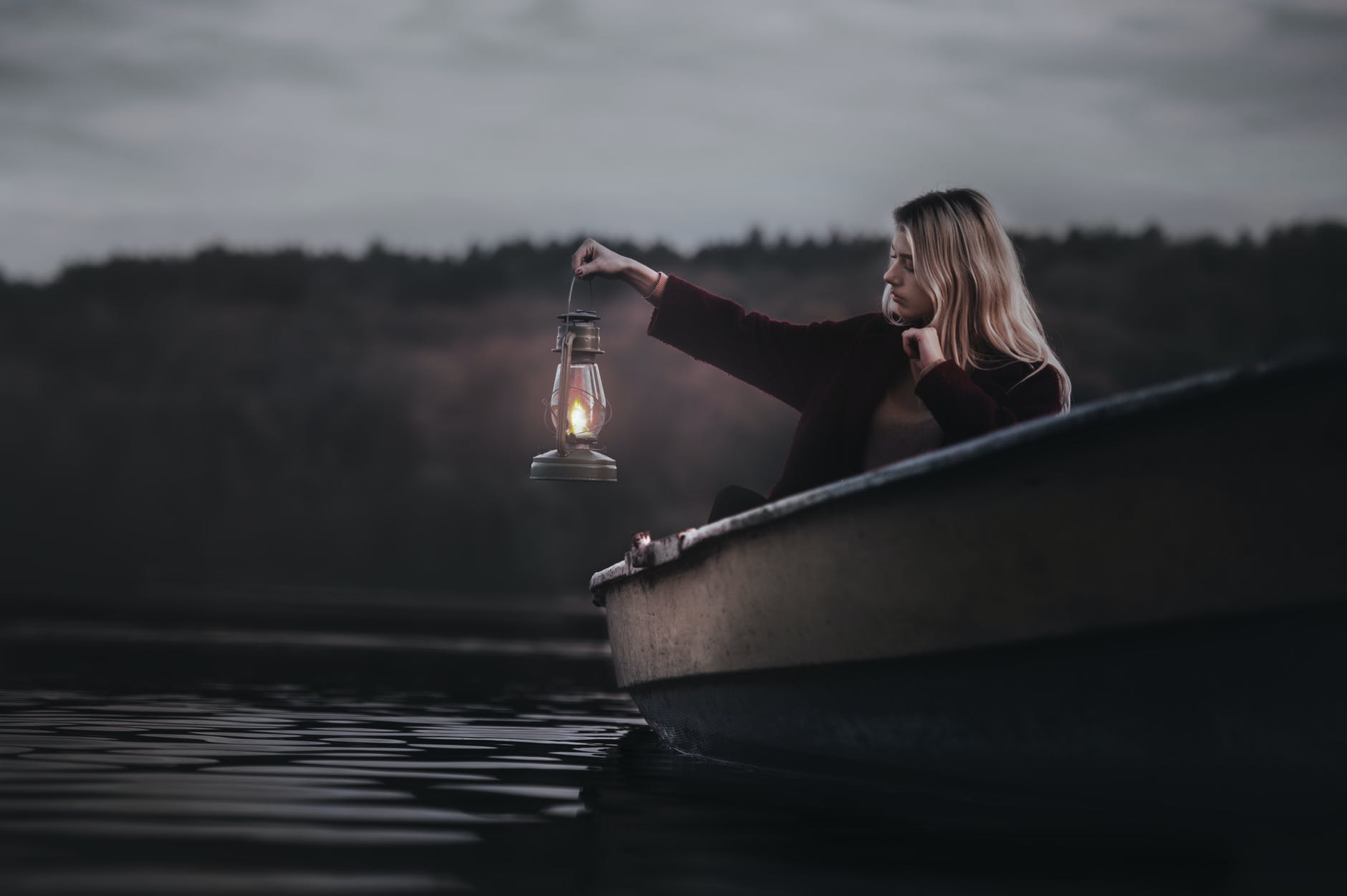woman on a boat holding gas lantern